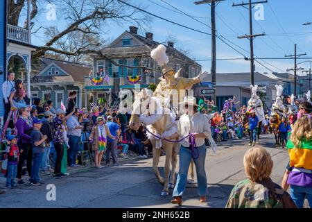 NEW ORLEANS, LA, USA - 19 FEBBRAIO 2023: Duke of Thoth Waves mentre passa la folla a cavallo alla sfilata Krewe of Thoth Mardi Gras su Magazine Foto Stock