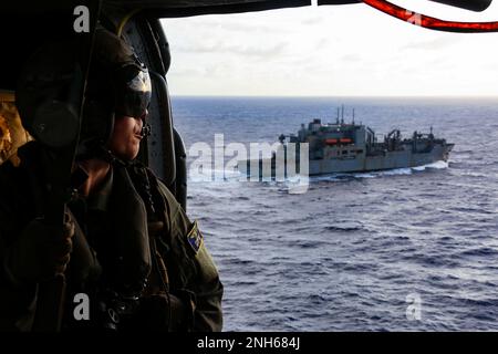 220719-N-DN347-1338 OCEANO PACIFICO (19 LUGLIO 2022) STATI UNITI Il Navy Chief Naval Air Crewman (elicottero) Brian Knox, di Costa Mesa, California, siede nella cabina di un elicottero MH-60s Sea Hawk, assegnato ai “Chargers” di Helicopter Sea Combat Squadron (HSC) 14, per un rifornimento in mare con la portaerei di classe Nimitz USS Abraham Lincoln (CVN 72) E nave da carico a secco e munizioni di classe Lewis e Clark USNS Washington Chambers (T-AKE 11) durante Rim of the Pacific (RIMPAC) 2022. Ventisei nazioni, 38 navi, tre sottomarini, più di 170 aerei e 25.000 personale partecipano al RIMPAC Foto Stock