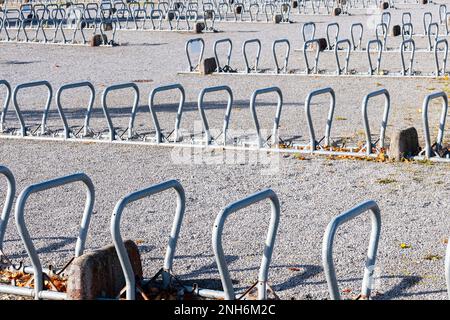 Grande gruppo di portabiciclette moderne a forma di staffa su un ampio parcheggio pubblico. Foto Stock