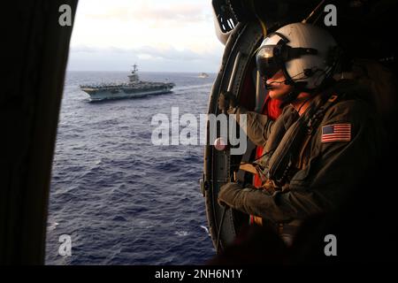 220719-N-DN347-1107 OCEANO PACIFICO (19 LUGLIO 2022) STATI UNITI Navy Naval Air Crewman (elicottero) 3rd Class Benjamin Mahaffey, di Flushing, N.Y., siede nella cabina di un elicottero MH-60s Sea Hawk, assegnato ai “Chargers” di elicottero Sea Combat Squadron (HSC) 14, per un rifornimento in mare con la portaerei di classe Nimitz USS Abraham Lincoln (CVN 72) E nave da carico a secco e munizioni di classe Lewis e Clark USNS Washington Chambers (T-AKE 11) durante Rim of the Pacific (RIMPAC) 2022. Vi partecipano ventisei nazioni, 38 navi, tre sottomarini, più di 170 aerei e 25.000 persone Foto Stock