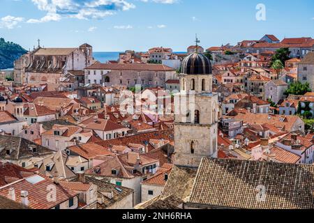 Vista attraverso i tetti di tegole rosse fino alla Chiesa di San Ignazio, con il campanile della Chiesa francescana sulla destra, nel centro storico di Dubrovnik in Croazia Foto Stock