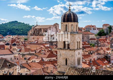 Vista attraverso i tetti di tegole rosse fino alla Chiesa di San Ignazio, con il campanile della Chiesa francescana sulla destra, nel centro storico di Dubrovnik in Croazia Foto Stock
