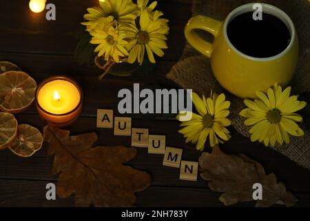 tazza di caffè su sfondo autunnale con foglie e fiori. Testo autunno Foto Stock