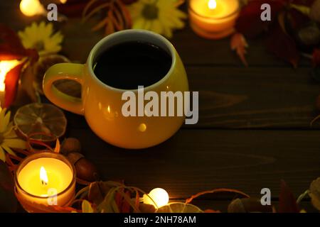 tazza di caffè su sfondo autunnale con foglie e fiori Foto Stock
