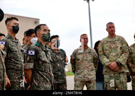 Il comandante dell'esercito della Repubblica di Corea del 5th il Gen. Kyu-Jun Lee ha visitato la Brigata dell'aviazione di combattimento del 2nd il 20 luglio 2022 per ricevere un brief sulle capacità dell'AH-64E V6 e dell'aquila grigia mq-1C. Il Lt. Gen. Lee si trova davanti al suo staff mentre viene informato su questi aerei e sulle loro capacità di squadra con equipaggio senza equipaggio. Foto Stock