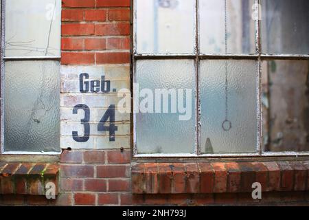 Vecchie finestre di fabbrica con l'iscrizione tedesca Geb. 34 (edificio 34). Foto Stock