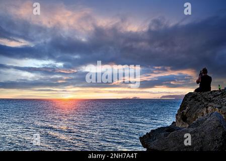 Giovane coppia che guarda il tramonto sulla spiaggia di Barbate vicino al faro di Trafalgar, Cádiz Foto Stock