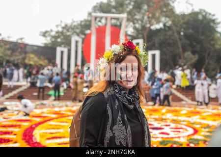 Uno straniero si pone per una foto con fiori sulla sua testa al monumento del Martire, o Shaheed Minar durante la Giornata Internazionale della Lingua Madre a Dhaka. Il Bangladesh rende omaggio al monumento del Martire, O Shaheed Minar, in occasione della Giornata Internazionale della Lingua Madre a Dhaka, la Giornata Internazionale della Lingua Madre si celebra in commemorazione del movimento in cui un certo numero di studenti è morto nel 1952, difendendo il riconoscimento di Bangla come lingua di stato dell'ex Pakistan orientale, ora Bangladesh. (Foto di Sazzad Hossain/SOPA Images/Sipa USA) Foto Stock