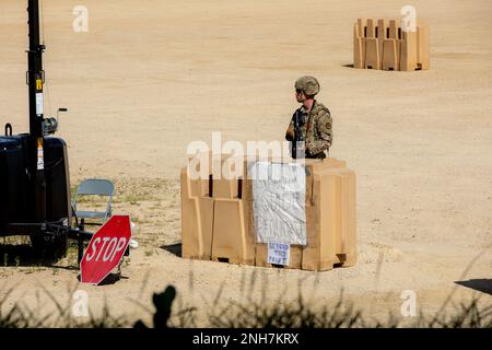 Un soldato della 231st Transportation Company, armato di una carabina M4, tira la guardia in un ingresso durante la difesa perimetrale alla Independence Tactical Training base il 22 luglio 2022 a Fort McCoy, Wisconsin. Questo esercizio fa parte del programma annuale WAREX in cui le unità della Riserva dell'Esercito conducono una formazione congiunta nell'ambito della Divisione formazione 78th. Foto Stock