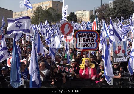 GERUSALEMME, ISRAELE - 20 FEBBRAIO: I manifestanti antigovernative detengono bandiere e segnali israeliani durante una manifestazione di massa al di fuori del parlamento israeliano (Knesset) contro il primo turno di votazioni sul nuovo piano del sistema giudiziario del governo israeliano il 20 febbraio 2023, a Gerusalemme, Israele. Credit: Eddie Gerald/Alamy Live News Foto Stock