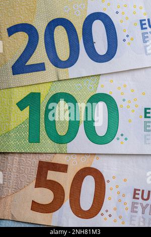 Diverse banconote in euro in fila primo piano, sfondo blu per i temi di finanza aziendale. Concetto di denaro mondiale, concetto di inflazione ed economia. Valuta Foto Stock