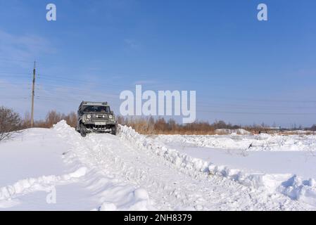 Fuoristrada russo SUV 'UAZ Hunter 469' 4x4 giri su una montagna innevata in inverno in un campo su una strada malva. Foto Stock