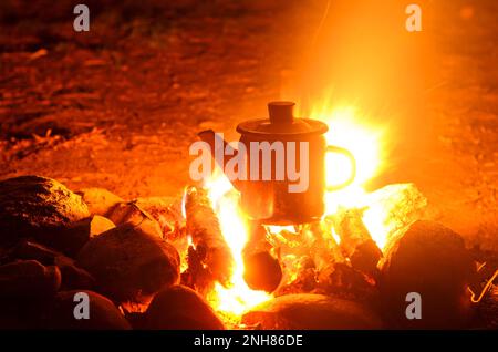 Stira il bollitore con una fiamma di notte. Foto Stock