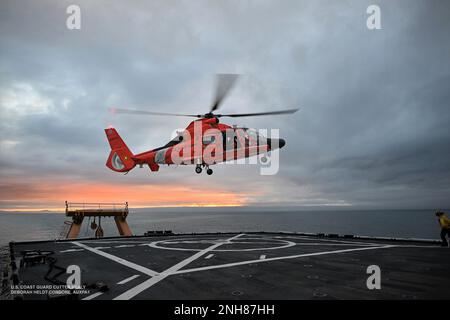 NEGLI STATI UNITI Stazione aerea della Guardia Costiera l'elicottero Kodiak MH-65 Dolphin atterra sul ponte di volo della Guardia Costiera Cutter Healy mentre transita vicino al Circolo polare Artico il 21 luglio 2022. La formazione viene condotta regolarmente per mantenere le qualifiche degli equipaggi a bordo di entrambe le risorse e mantenere la competenza in una varietà di evoluzioni. STATI UNITI Guardia costiera Foto ausiliaria di Deborah Heldt. Foto Stock