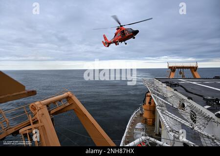 Una stazione aerea della Guardia Costiera degli Stati Uniti MH-65 l'equipaggio d'elicottero Dolphin si avvicina al ponte di volo della Guardia Costiera Healy Cutter nel Golfo dell'Alaska il 21 luglio 2022. La formazione viene condotta regolarmente per mantenere le qualifiche dell'equipaggio a bordo di entrambi i beni e mantenere la competenza in una varietà di evoluzioni. Foto ausiliaria della Guardia Costiera degli Stati Uniti di Deborah Heldt. Foto Stock