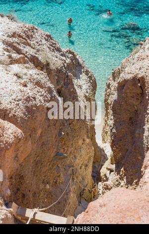 Stretto passaggio con scala in legno per scendere alla spiaggia di Tsigrado, Milos Foto Stock