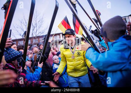 20 febbraio 2023, Baviera, Fischen im Allgäu: Il campione del mondo Slalom gigante parallelo Alexander Schmid cammina attraverso un trellis di sci durante la sua accoglienza dopo i Campionati del mondo di sci alpino a Courchevel e Meribel. Foto: Tom Weller/dpa Foto Stock