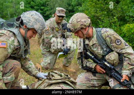 Un soldato, a sinistra, racconta le lesioni simulate di un incidente a SPC. Desiree Martinez, a destra, una medica di combattimento con 3rd battaglione, 112th Field Artillery Regiment, 44th Fanteria Brigata Combat Team, durante Exportable Combat Training Capability 22-01 su Fort Drum, NY, 21 luglio 2022. Foto Stock