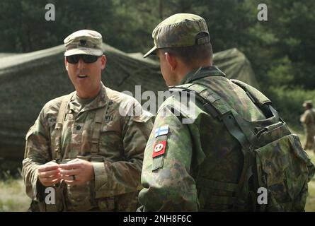 STATI UNITI David Henderson, comandante di 1st battaglione, 6th reggimento di artiglieria di campo, 41st Brigata di artiglieria di campo, Pekka Kinnunen, comandante del Satakunta Artillery Regiment, pori Brigade, discutono le procedure di sparo durante una formazione multinazionale dal vivo come parte dell'Esercitazione Dynamic Front 2022 (DF22), Grafenwoehr Training Area, Germania, 22 luglio 2022. DF22, guidato da 56th Artillery Command e Stati Uniti Army Europe and Africa Directed, è la prima esercitazione sugli incendi integrati degli alleati e dei partner della NATO a guida statunitense nel teatro europeo, incentrata sull'interoperabilità degli incendi Foto Stock