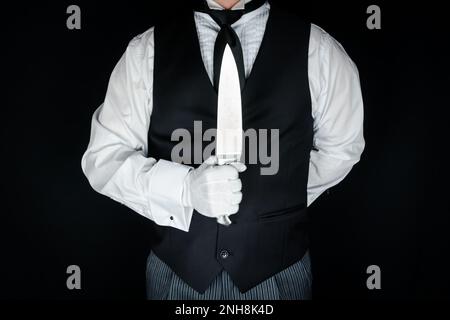 Ritratto di Butler in gilet nero e guanti bianchi che tiene un coltello affilato. Il concetto di Butler lo ha fatto. Foto Stock