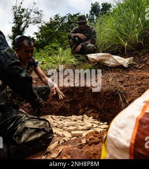 Royal Thai Army Explosive Ordnance tecnici di smaltimento posizionare le mine anti-persona per la detonazione su larga scala a Ta Mor Roi zona di formazione durante Humanitarian Mine Action EOD livello 3 nella provincia di Surin, Thailandia, 27 luglio 2022. Le forze Armate reali Thai e Americane lavorano insieme per formare gli studenti del Thailand Mine Action Center nel livello EOD 3 al fine di sviluppare una capacità EOD per aiutare la missione di TMAC di diventare senza mine. Questa partnership è in linea con gli Stati Uniti Programma di azione umanitaria per le miniere del Dipartimento della Difesa, che assiste le nazioni partner colpite dalle mine terrestri, resti esplosivi Foto Stock