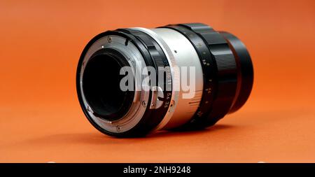 RESEN, MACEDONIA. 20 FEBBRAIO 2023-vintage film lente su arancione backround.nippon kogaku nikkor-q 135mm F3,5 manuale. Foto Stock