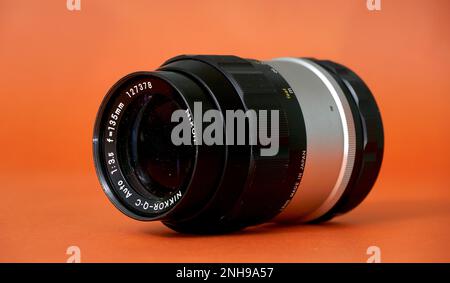 RESEN, MACEDONIA. 20 FEBBRAIO 2023-vintage film lente su arancione backround.nippon kogaku nikkor-q 135mm F3,5 manuale. Foto Stock