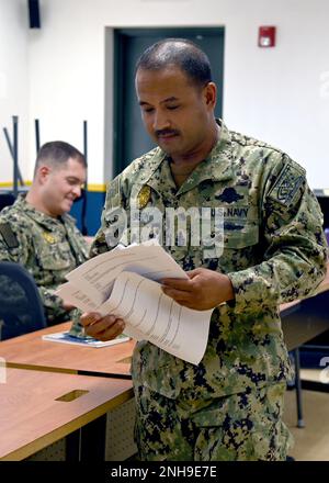 220727-N-OX321-1005 AEROSTAZIONE NAVALE SIGONELLA, Italia (27 luglio 2022) – Senior Chief Master-at-Arms Peter Limson, di New York City, e l'agente esecutivo designato per il programma di qualificazione delle insegne della Naval Security Force presso la Naval Air Station Sigonella, Passa gli esami Naval Security Force Master Specialist e NSF Senior Specialist alle qualifiche iniziali di NAS Sigonella, 27 luglio 2022. Il nuovo programma di qualificazione per insegne NSF stabilisce standard di prestazioni che possono essere utilizzati per assistere nei processi di assegnazione, promozione e selezione degli ufficiali, e fornisce un riconoscimento visivo Foto Stock