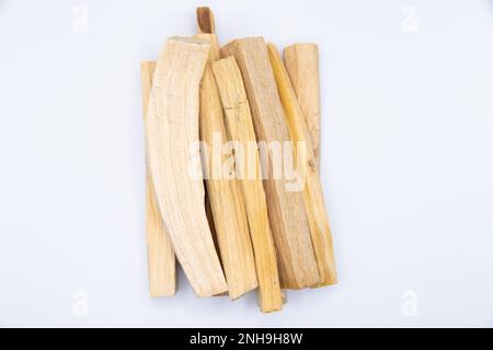 Vista dall'alto foto a colori primo piano di bastoni di legno di Palo santo isolati su sfondo bianco. Foto Stock