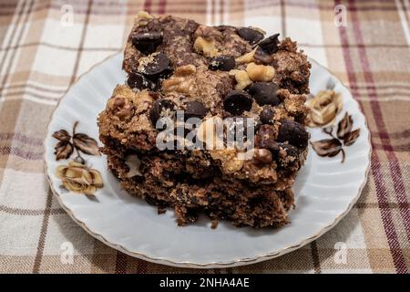 Torta di spezie con salsa di mele con uvetta, patatine al cioccolato e noci su un piatto a fiori piuttosto marrone su una tovaglia a platea a Taylors Falls, Minnesota USA Foto Stock