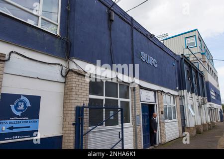 Sede principale del Southend United Football Club presso Roots Hall, Southend-on-Sea, Essex. Segno blu che indica 'SUFC'. Uomo in piedi alla porta. Foto Stock