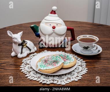 Tè di Natale con biscotti di zucchero decorati, una teiera di babbo natale e un cervo ad un tavolo a Taylors Falls, Minnesota USA. Foto Stock