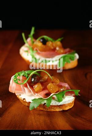 toast con chutney di mele fatto in casa, prosciutto, ricotta e rucola Foto Stock