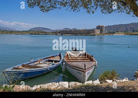 Barche da pesca e Castello triangolare veneziano del 15th ° secolo lungo il canale di Vivari vicino al Parco Nazionale di Butrint, Contea di Vlorë, Albania meridionale Foto Stock