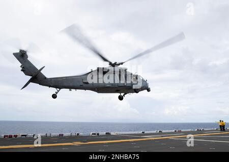 220729-N-CM110-1054 OCEANO PACIFICO (29 luglio 2022) – un elicottero MH-60s Sea Hawk assegnato a Helicopter Sea Combat Squadron (HSC) 23 decolora dal ponte di volo a bordo di un vettore d'assalto anfibio USS Tripoli (LHA 7), 29 luglio 2022. Tripoli opera nell'area delle operazioni della flotta 7th degli Stati Uniti per migliorare l'interoperabilità con alleati e partner e fungere da pronta forza di risposta per difendere la pace e mantenere la stabilità nella regione dell'Indo-Pacifico. Foto Stock