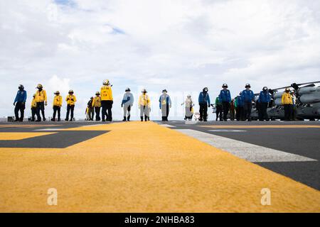 220729-N-CM110-1063 OCEANO PACIFICO (29 luglio 2022) – i marinai e i marines eseguono un depliuto di corpi estranei (FOD) sul ponte di volo a bordo della nave d'assalto anfibio USS Tripoli (LHA 7), 29 luglio 2022. Tripoli opera nell'area delle operazioni della flotta 7th degli Stati Uniti per migliorare l'interoperabilità con alleati e partner e fungere da pronta forza di risposta per difendere la pace e mantenere la stabilità nella regione dell'Indo-Pacifico. Foto Stock