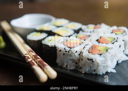 deliziosi panini di riso con pesce o makis, con le loro bacchette orientali Foto Stock