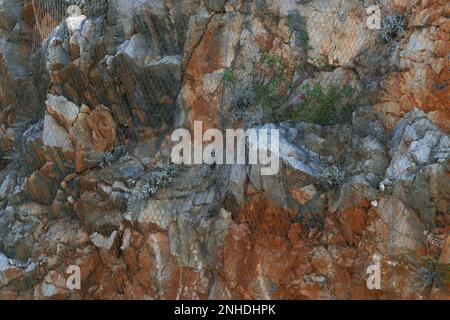 Una rete di sicurezza che copre le scogliere. Protezione contro la caduta di rocce. Foto Stock