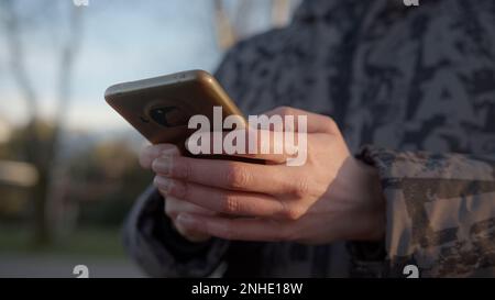 Comunicazione moderna a portata di mano: Una vista ravvicinata della messaggistica uomo a mano su uno smartphone all'aperto Foto Stock