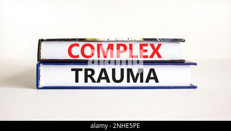 Simbolo di trauma complesso. Concetto parole trauma complesso sui libri. Bellissimo sfondo bianco tavolo. Psicologia aziendale concetto di trauma complesso. Copia Foto Stock