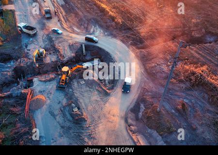 Questa straordinaria foto mostra le ultime tecnologie ingegneristiche per la costruzione di strade. L'immagine presenta un team di ingegneri che posano utility un Foto Stock