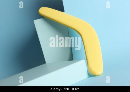 Composizione creativa con boomerang in legno giallo su fondo turchese Foto Stock