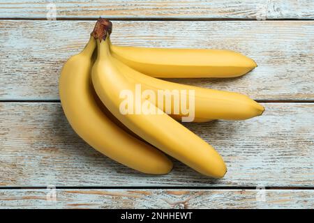 Mazzo di banane gialle mature su un tavolo di legno chiaro Foto Stock