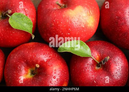 Deliziose mele rosse mature con gocce d'acqua sul tavolo, piatto Foto Stock