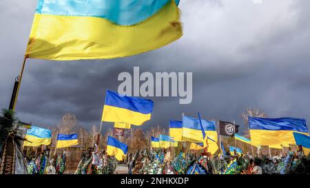 Kiev, Kiev Oblast, Ucraina. 21st Feb, 2023. Le bandiere nazionali ucraine blu e gialle sono soffiate dal vento e i fiori giacciono sulle tombe dei soldati uccisi in combattimento contro le forze russe, nel cimitero di Lisove, nella capitale dell'Ucraina. Mentre l'invasione su larga scala dell'Ucraina da parte delle forze russe si avvicina al suo primo anniversario, il tasso di sinistri è molto alto, anche se i numeri esatti sono sconosciuti. Un minimo di 13 mila soldati ucraini hanno perso la vita. (Credit Image: © Dominika Zarzycka/SOPA Images via ZUMA Press Wire) SOLO PER USO EDITORIALE! Non per USO commerciale! Foto Stock