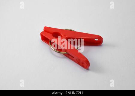 Clothespin di plastica rossa isolato su sfondo bianco. Clip in plastica Foto Stock