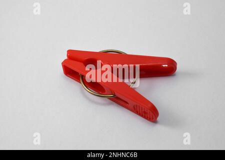 Clothespin di plastica rossa isolato su sfondo bianco. Clip in plastica Foto Stock