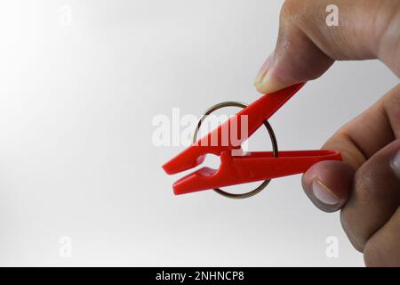 Clothespin di plastica rossa isolato su sfondo bianco. Clip in plastica Foto Stock