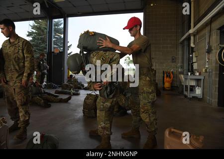 Il Sig. Anthony Husey fotografa i soldati del 143rd° Reggimento della fanteria aerea, 1st° Battaglione, Charlie Company, del Rhode Island mentre preparano i loro attrezzi per un salto serale alla fine della sessione annuale di allenamento il 31 luglio 2022. La loro missione come unità aerea è altamente specializzata, e l'unità treni per essere il migliore nel loro campo. (Foto della Guardia Nazionale del Minnesota di Anthony Housey) Foto Stock