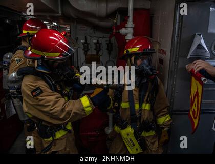 I marinai DELL'OCEANO PACIFICO (30 luglio 2022), assegnati al cacciatorpediniere missilistico guidato della classe Arleigh Burke USS Gridley (DDG 101) combattono un incendio simulato durante un'esercitazione generale. Abraham Lincoln Carrier Strike Group sta conducendo operazioni di routine nella flotta degli Stati Uniti 3rd. Foto Stock